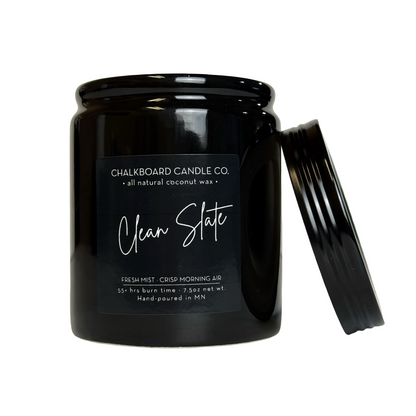 Black jar candle (Chalkboard Candle Co.) labeled 'Clean Slate' with lid leaning against the jar